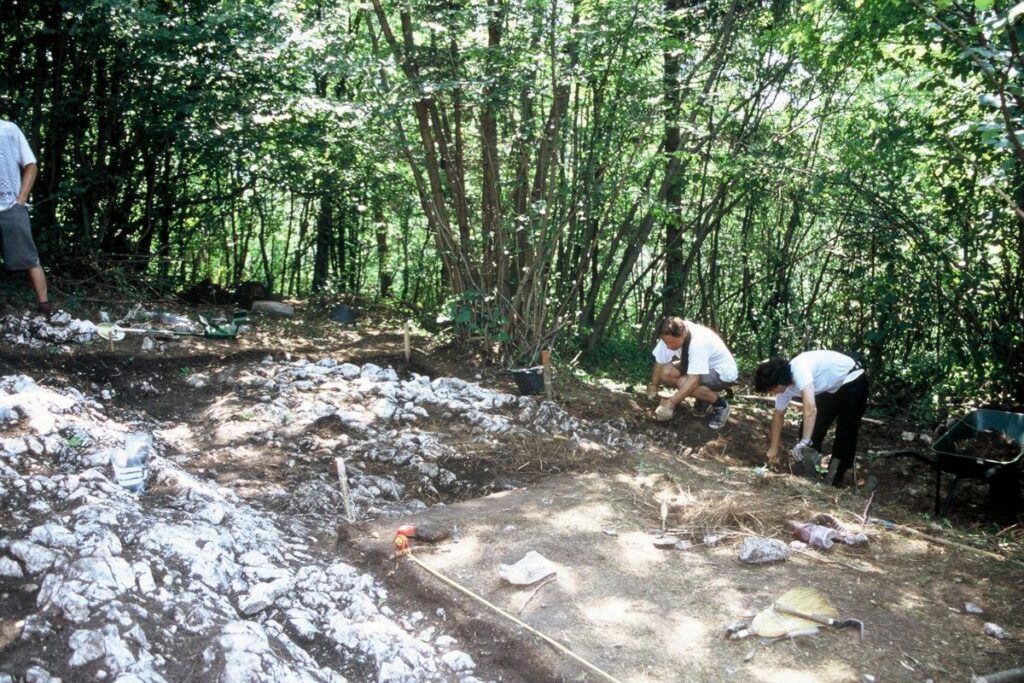 Dve osebi, ki delata na arheološkem najdišču.